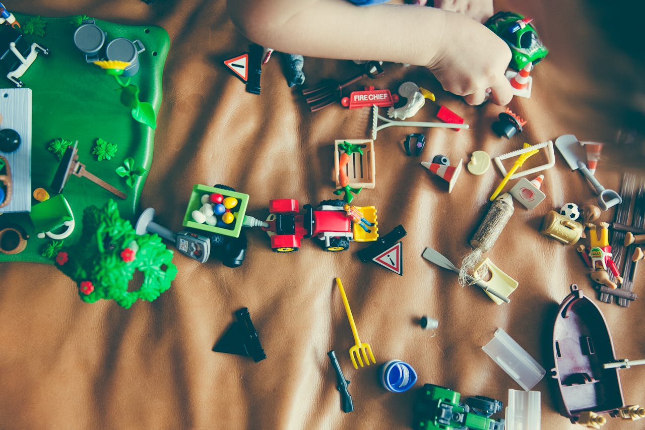 Children's hands playing with colorful toys on a mat, sparking creativity and fun.