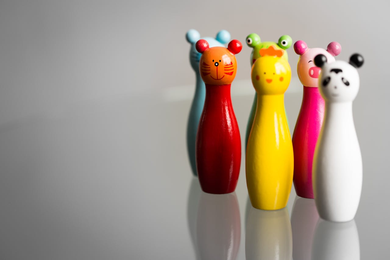 Five vibrant animal-shaped toy figurines in various colors on a glossy surface.